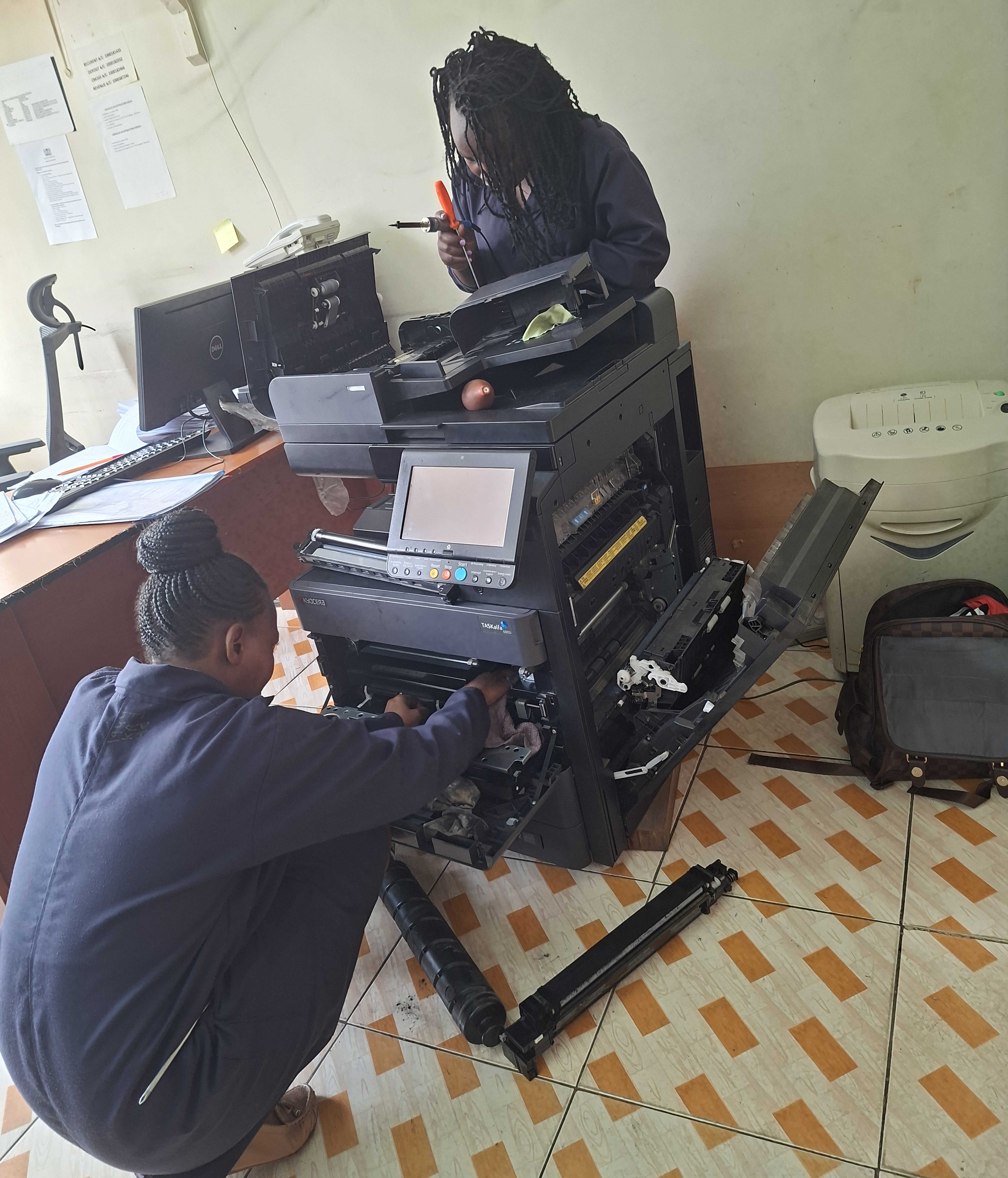 PrintFix Technologies certified technicians servicing a Kyocera multifunction printer on-site at a client location in Kenya